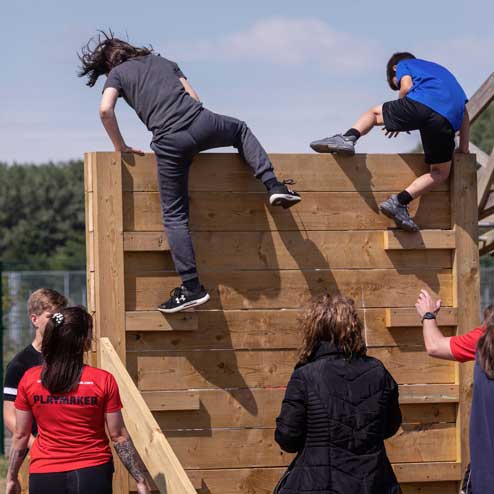 children climbing obstacle wall