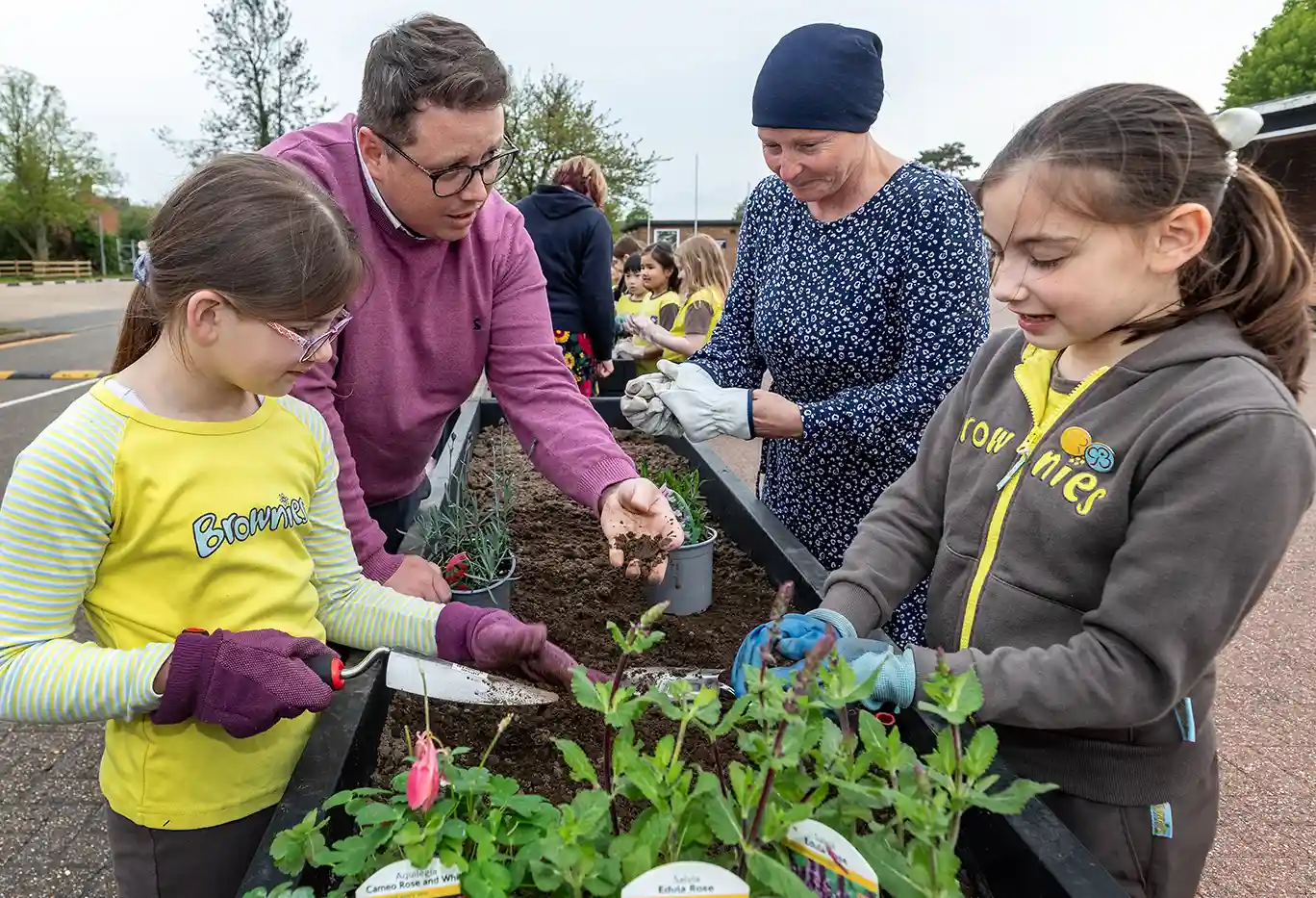 Brownies planting plants in a trough planter, led by Scott Chalmers, Urban&Civic's Landscape Design Manager