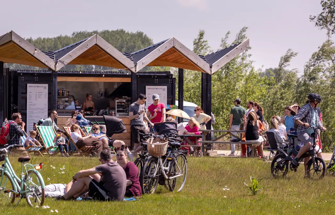 People sitting outside the café by the lake